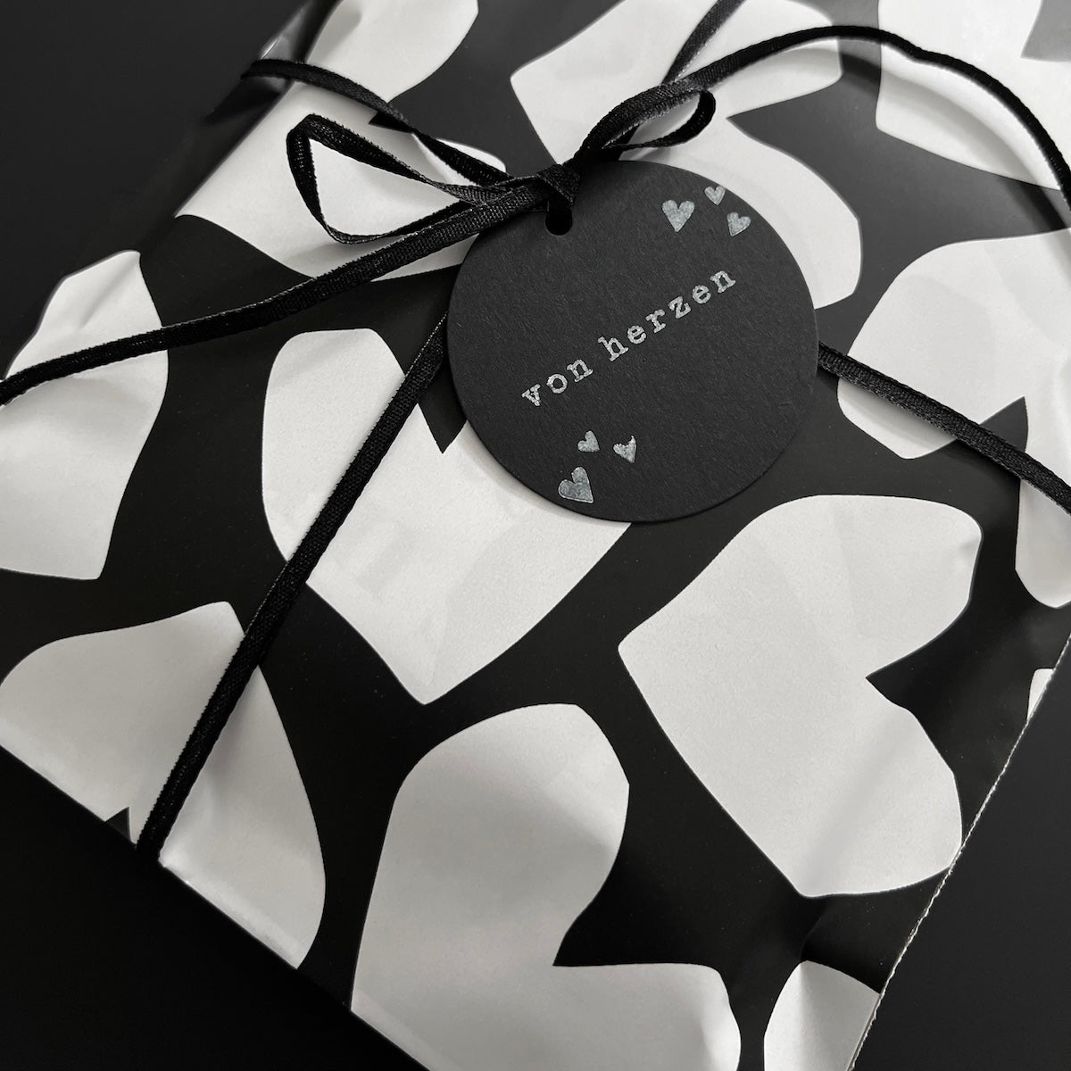 Geschenktüte mit Herzmuster und schwarzem Schwarzem Schleifenband mit Geschenkanhänger, gestempelt