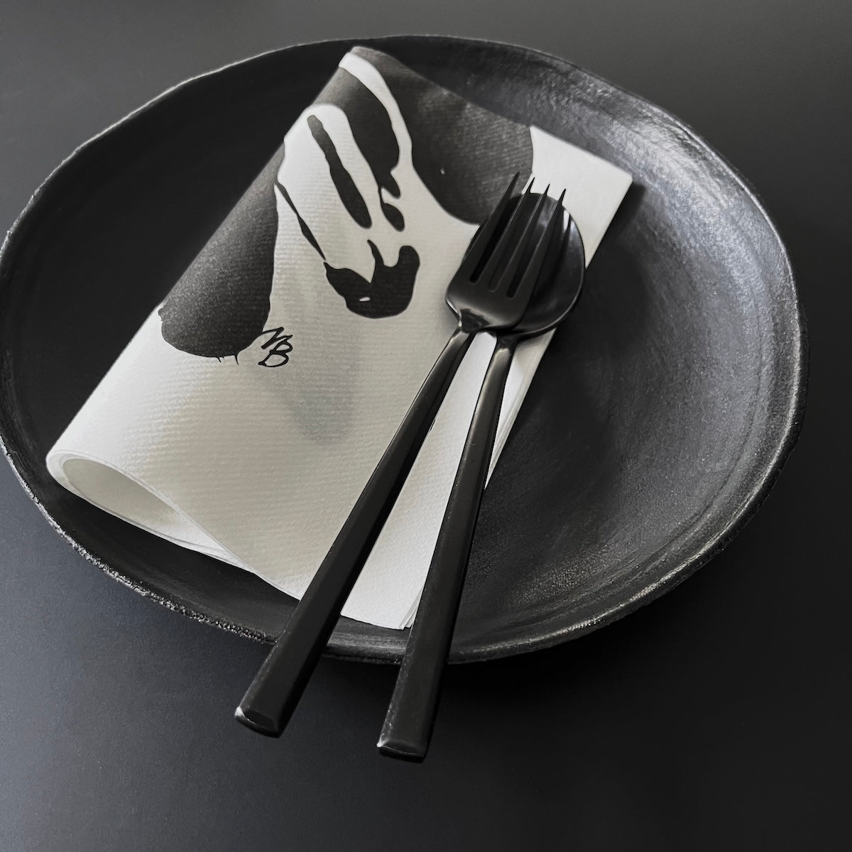 Schwarzes Geschirr mit Design Papierserviette