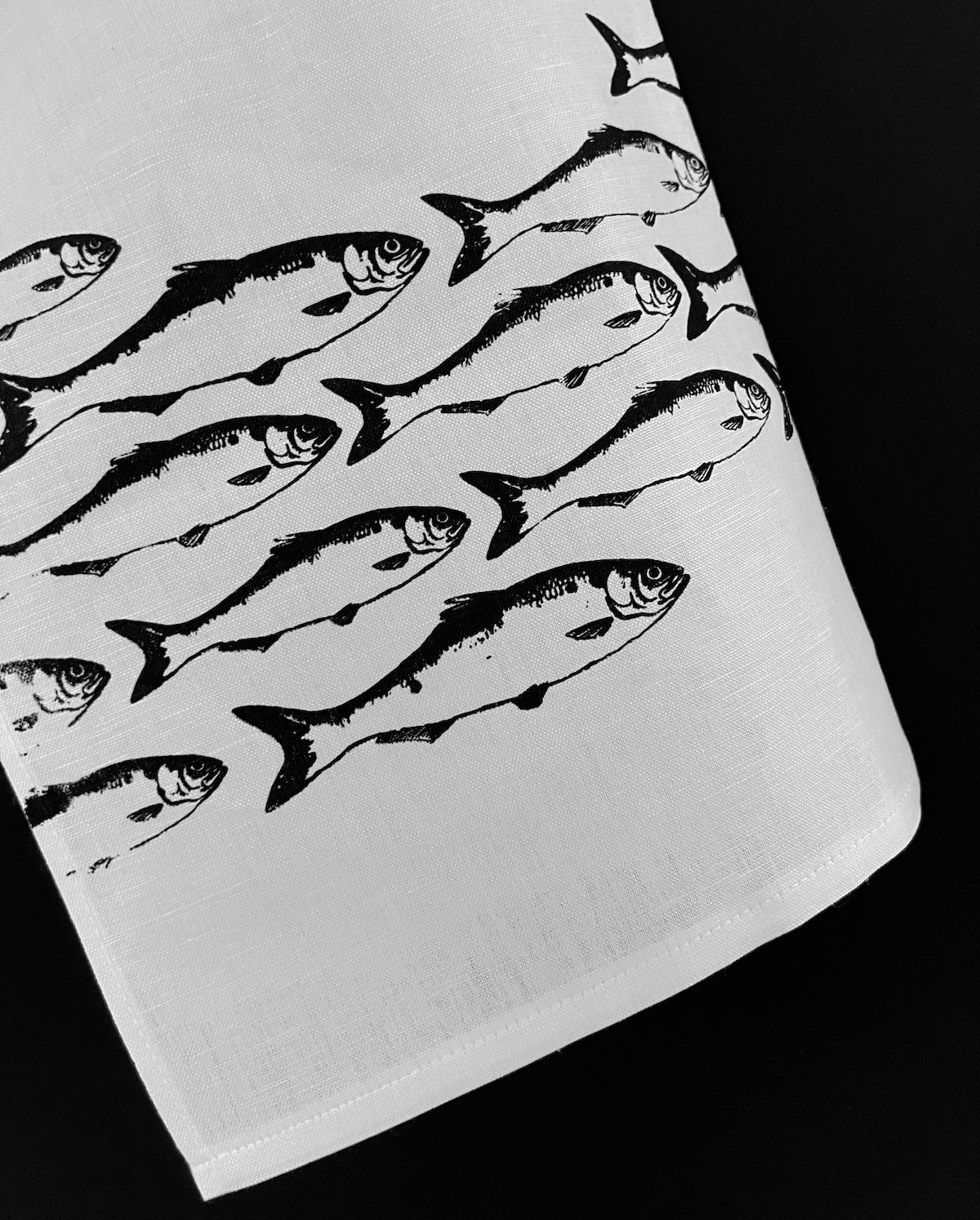Geschirrhandtuch aus weißem Halbleinen mit hochwertigem Fischschwarm Siebdruckmotiv. 