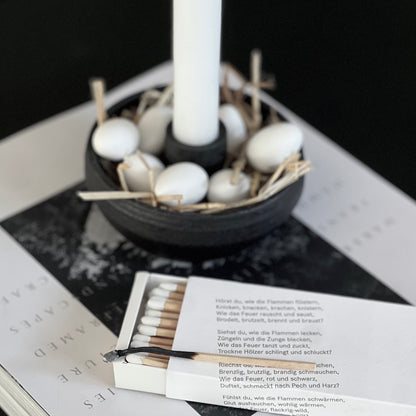 Schwarzer Kerzenkalter mit Dekoration aus Keramik.