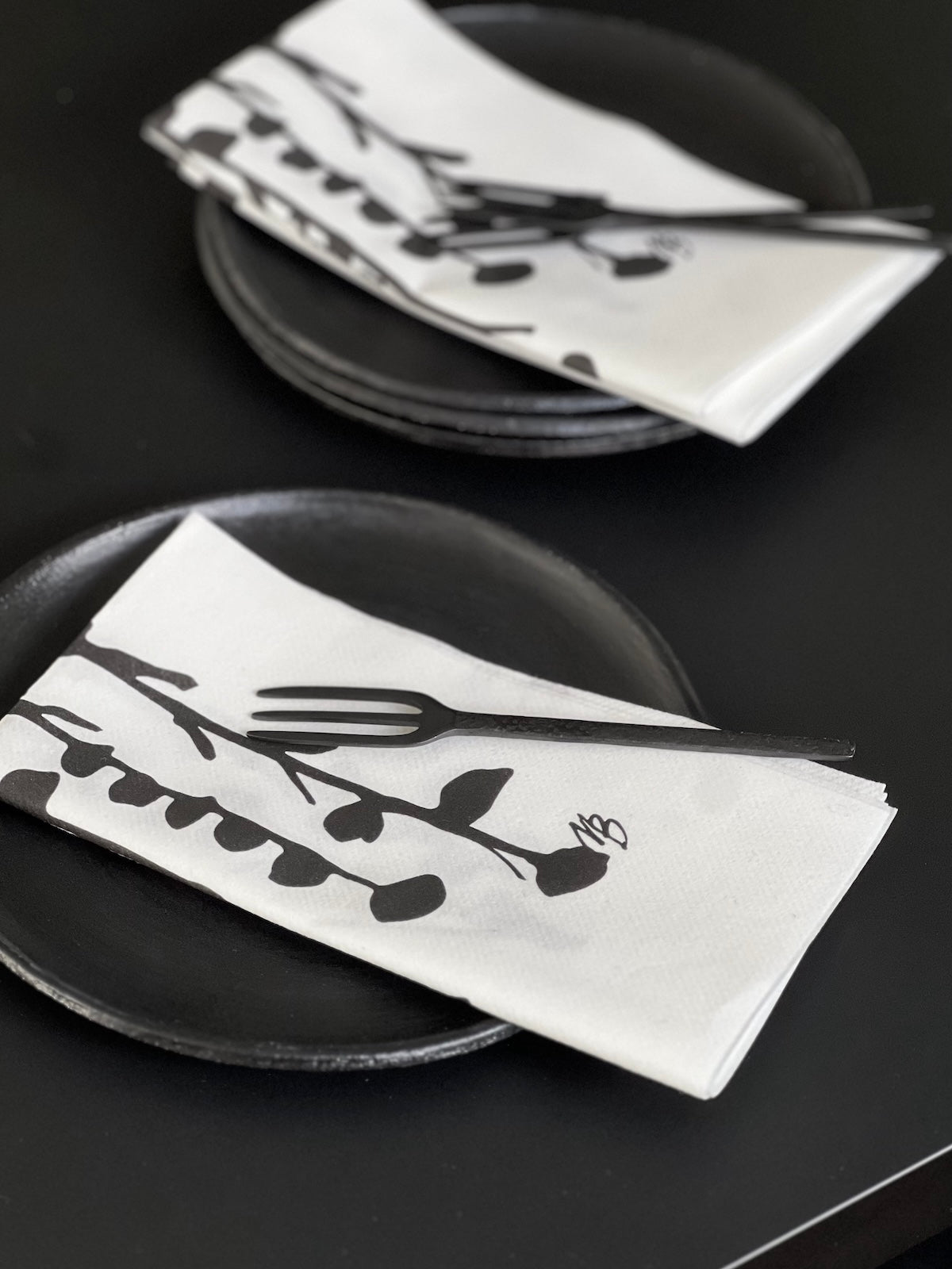 Papierservietten mit Floralem Muster. Textile Struktur in schwarz weiß.