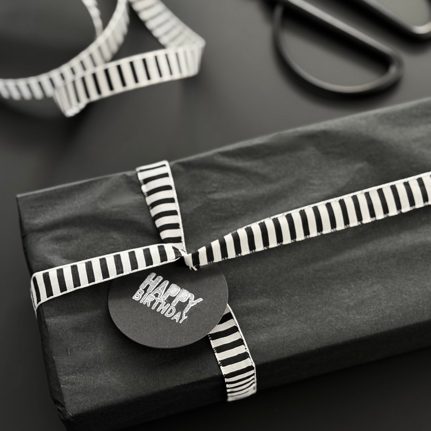 Schwarz Weiß gestreiftes Schleifenband um Geschenke zu verpacken.